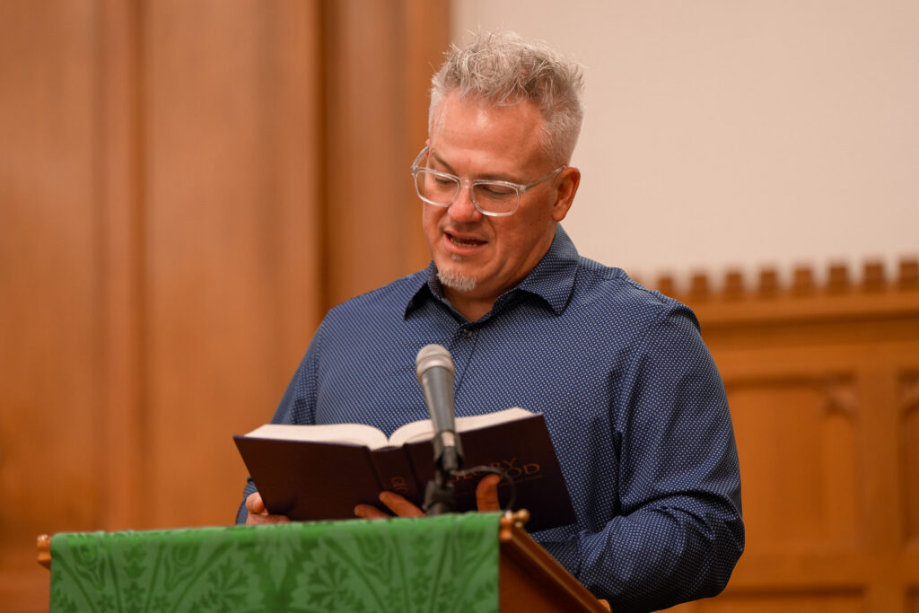 Keith teaching from the Bible at a podium